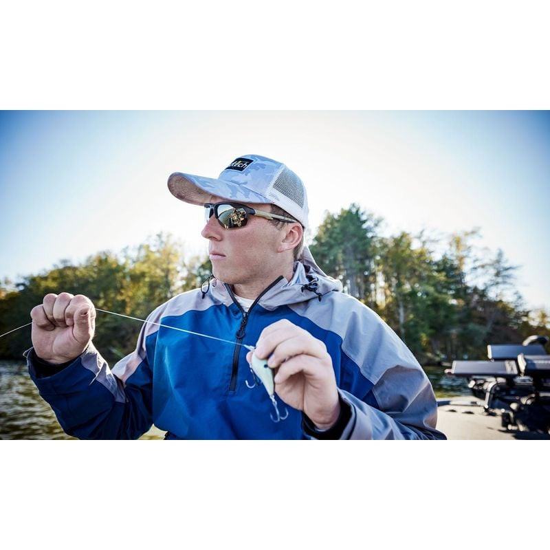 Pêcheur sur bateau portant lunettes Wiley X WX JAKL Tan, tenant leurre, idéales pour activités nauti
