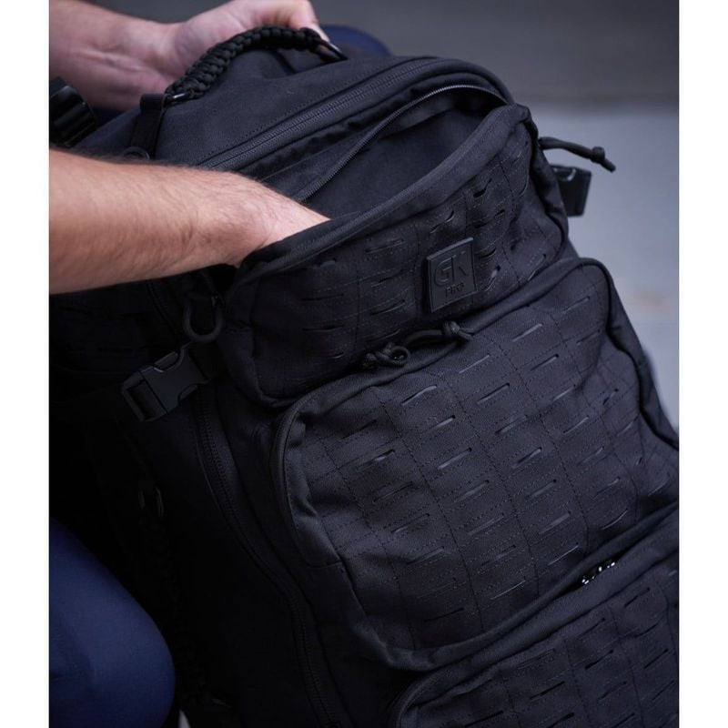Image lifestyle d'une personne ouvrant le sac à dos tactique GK Pro Blake 40L, montrant le compartim