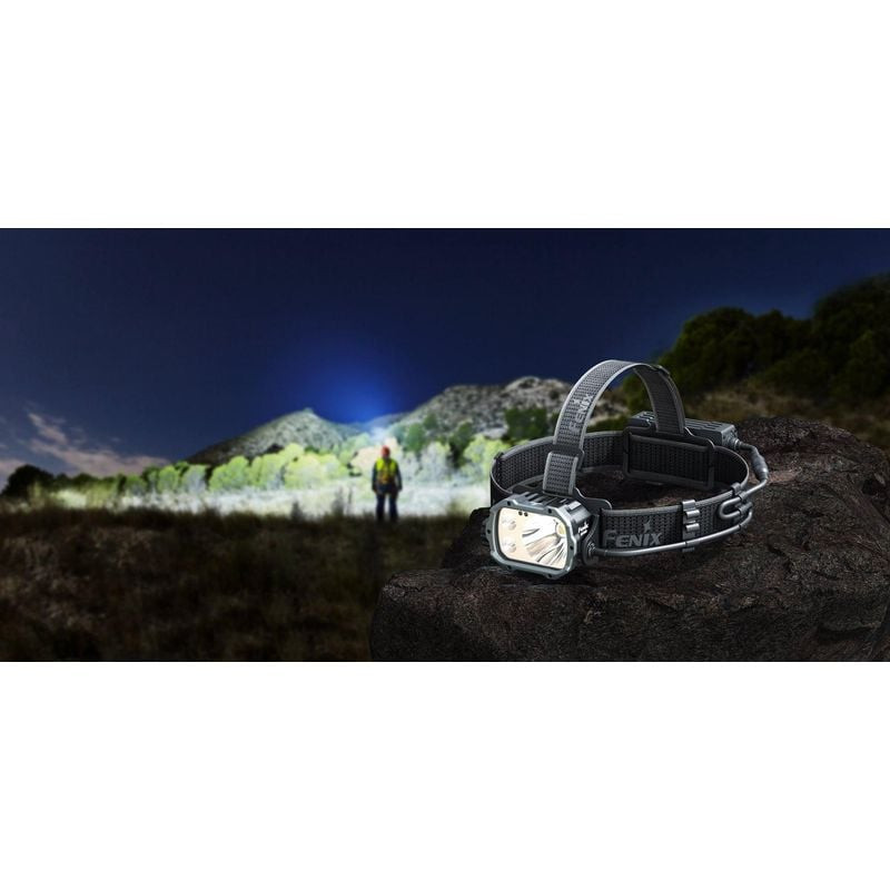 Lampe frontale Fenix HP35R en action éclairant une zone extérieure sombre avec un faisceau lumineux 