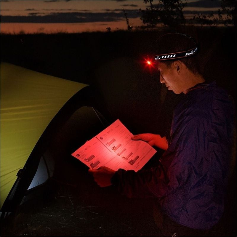 Lampe frontale Fenix HM70R montée sur casque, montrant le mode lumière rouge pour la préservation de