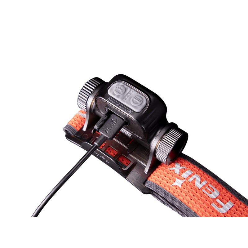 Gros plan sur la lampe frontale Fenix HM65R-T V2.0 montrant la molette rotative et le sifflet d'urge