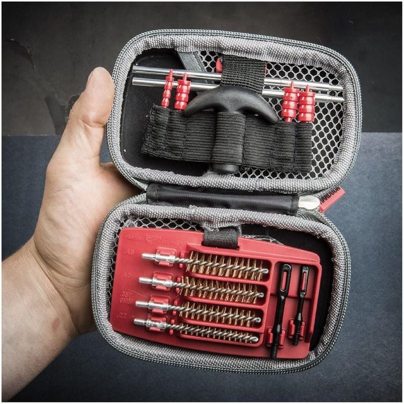 Personne utilisant le kit de nettoyage Gun Boss Real Avid pour nettoyer le canon d'un pistolet avec 
