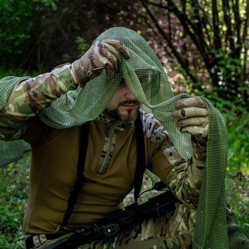 Echarpe filet Vert OD de General Army Store portée en extérieur pour camouflage tactique.