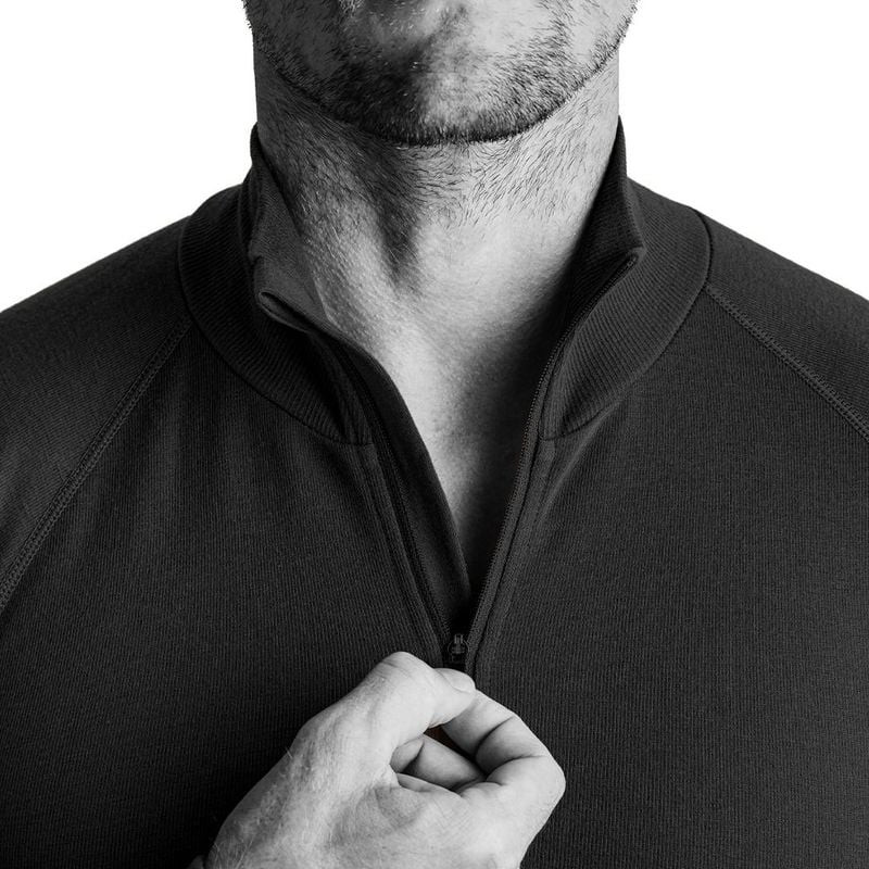 Gros plan d'une main tirant la fermeture quart de zip d'un sweat thermique noir A10 Thermo Performer